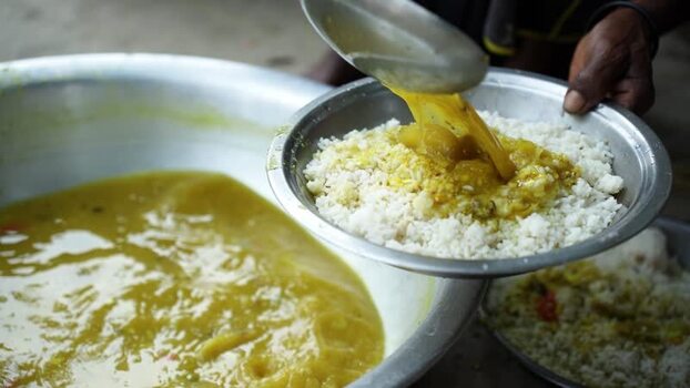 View of a person pouring yellow dal over white rice Bangladesh. View of a person pouring yellow dal over white rice Bangladesh.