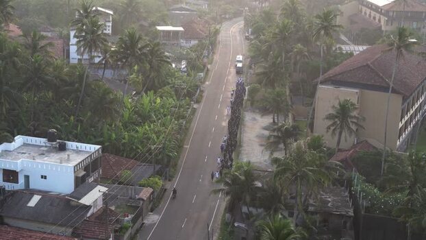 View of people walking along a road lined with palm trees Sri Lanka. View of people walking along a road lined with palm trees Sri Lanka.