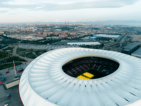 Aerial view of Riyadh Air Metropolitano Stadium with its distinctive circular roof and green pitch set against the urban landscape of Madrid Comunidad de Madrid Spain.