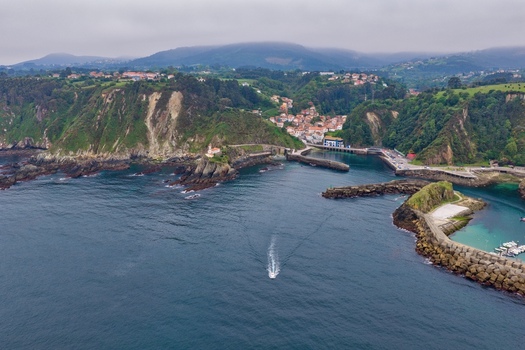 Aerial view of the coastal village of Cudillero with its colorful houses nestled between steep green cliffs and a small harbor on the Cantabrian Sea Cudillero Asturias Spain. Aerial view of the coastal village of Cudillero with its colorful houses nestled between steep green cliffs and a small harbor on the Cantabrian Sea Cudillero Asturias Spain.