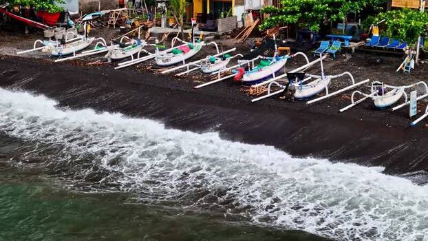 Aerial view of Jukung boats on a black sand beach Indonesia.