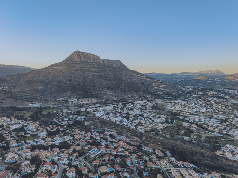 Aerial view of the Penyal d Ifac mountain rising above the residential rooftops and coastal landscape of Calp Valencian Community Spain. Aerial view of the Penyal d Ifac mountain rising above the residential rooftops and coastal landscape of Calp Valencian Community Spain.