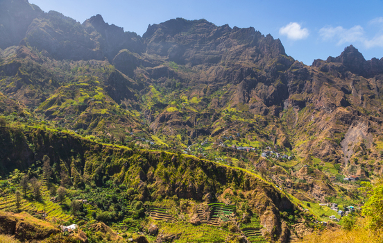 Aerial view of Trilha do Vale do Paul featuring lush green terraced fields on steep volcanic mountainsides with small village houses in the valley in Faja de Cima Paul Cabo Verde.