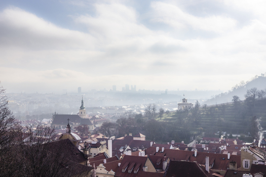 View of historic rooftops and church towers under a misty sky with terraced hillsides Prague Prague Czechia. View of historic rooftops and church towers under a misty sky with terraced hillsides Prague Prague Czechia.