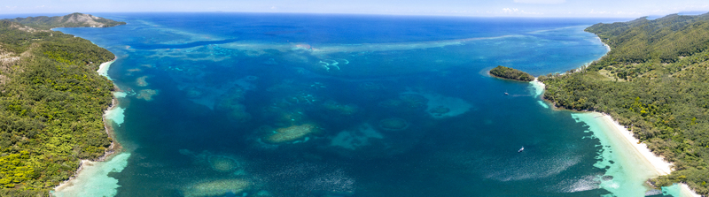 Aerial view of the turquoise waters and lush tropical coastline of Guanaja island featuring coral reefs and white sand beaches in Guanaja Bay Islands Department Honduras. Aerial view of the turquoise waters and lush tropical coastline of Guanaja island featuring coral reefs and white sand beaches in Guanaja Bay Islands Department Honduras.