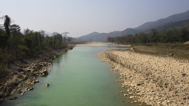 View of a turquoise river flowing through a lush valley Nepal.