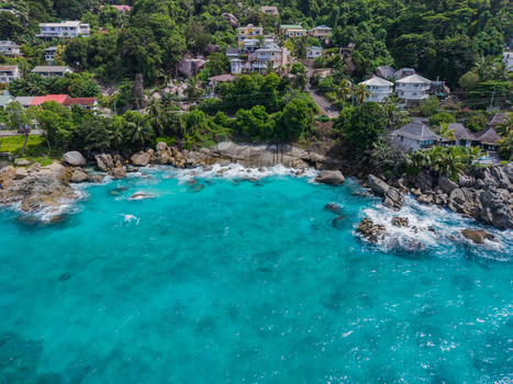 Aerial view of turquoise waters meet rugged coastline homes nestled amid lush greenery a vibrant dance of nature and architecture Vista do Mar Mahe Island Seychelles. Aerial view of turquoise waters meet rugged coastline homes nestled amid lush greenery a vibrant dance of nature and architecture Vista do Mar Mahe Island Seychelles.