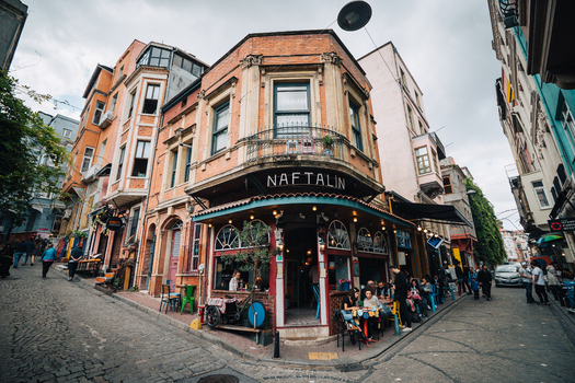 Istanbul Turkiye 06 October 2019 View of the vibrant Naftalin Cafe its warm lights spilling onto the cobblestone streets a beacon of cozy charm amidst the historic buildings. Istanbul Turkiye 06 October 2019 View of the vibrant Naftalin Cafe its warm lights spilling onto the cobblestone streets a beacon of cozy charm amidst the historic buildings.