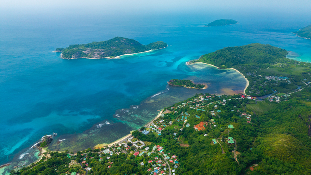 Aerial view of Cap Ternay with its lush green hills coastal vegetation and turquoise waters surrounding the bay in Cap Ternay Port Glaud Seychelles. Aerial view of Cap Ternay with its lush green hills coastal vegetation and turquoise waters surrounding the bay in Cap Ternay Port Glaud Seychelles.