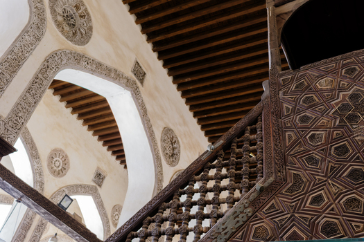 View of the intricate wooden carvings and decorative stone arches inside the Mosque of al Salih Tala i in Cairo Egypt. View of the intricate wooden carvings and decorative stone arches inside the Mosque of al Salih Tala i in Cairo Egypt.