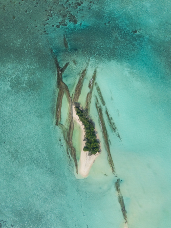 Aerial view of the small island with lush green trees surrounded by turquoise water Thuraakunu Thiladhunmathee Uthuruburi Maldives. Aerial view of the small island with lush green trees surrounded by turquoise water Thuraakunu Thiladhunmathee Uthuruburi Maldives.