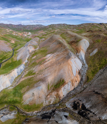 Aerial view of the colorful geothermal landscape of Grensdalur featuring winding streams vibrant green moss and volcanic slopes in Sveitarfelagid Olfus Iceland. Aerial view of the colorful geothermal landscape of Grensdalur featuring winding streams vibrant green moss and volcanic slopes in Sveitarfelagid Olfus Iceland.
