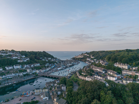 Aerial view of the coastal town of Looe with its harbor boats and historic buildings nestled along the river in Looe Cornwall United Kingdom. Aerial view of the coastal town of Looe with its harbor boats and historic buildings nestled along the river in Looe Cornwall United Kingdom.