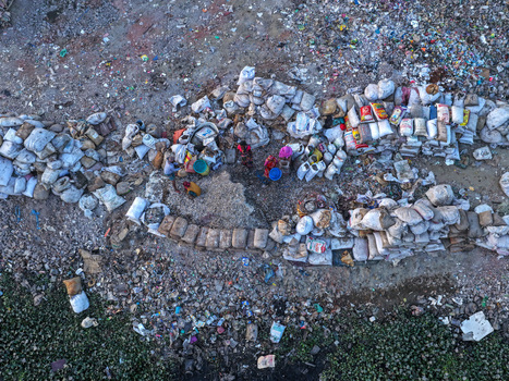 Aerial view of people sorting through piles of waste and recyclables in sacks along the Buriganga Riverbank in Dhaka Dhaka Division Bangladesh. Aerial view of people sorting through piles of waste and recyclables in sacks along the Buriganga Riverbank in Dhaka Dhaka Division Bangladesh.