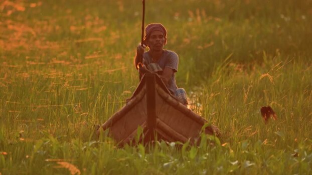 View of a fisherman in a wooden boat in a marsh Bangladesh. View of a fisherman in a wooden boat in a marsh Bangladesh.