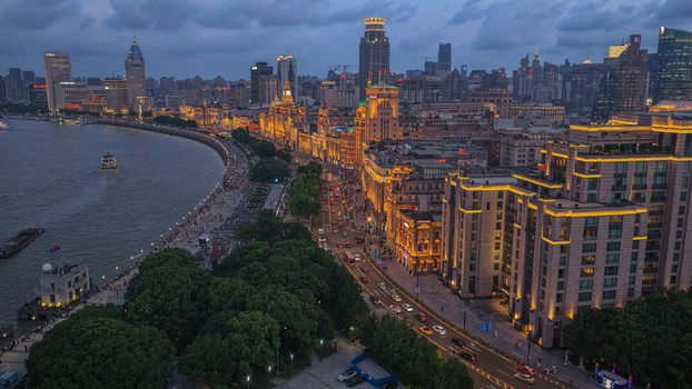 Aerial view of the illuminated historic buildings along the Bund and the Huangpu River at dusk in Shanghai Shanghai China. Aerial view of the illuminated historic buildings along the Bund and the Huangpu River at dusk in Shanghai Shanghai China.