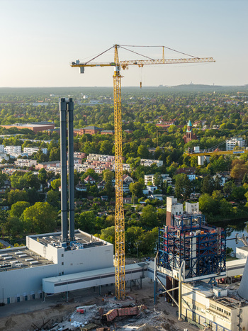 Aerial view of Combined Heat and Power Plant Lichterfelde during deconstruction featuring a tall yellow tower crane industrial chimneys and surrounding urban greenery in Berlin Berlin Germany. Aerial view of Combined Heat and Power Plant Lichterfelde during deconstruction featuring a tall yellow tower crane industrial chimneys and surrounding urban greenery in Berlin Berlin Germany.