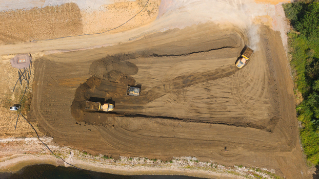 Aerial view of heavy machinery and excavators performing groundworks at the Black Cat Roundabout construction site in Chawston England United Kingdom. Aerial view of heavy machinery and excavators performing groundworks at the Black Cat Roundabout construction site in Chawston England United Kingdom.