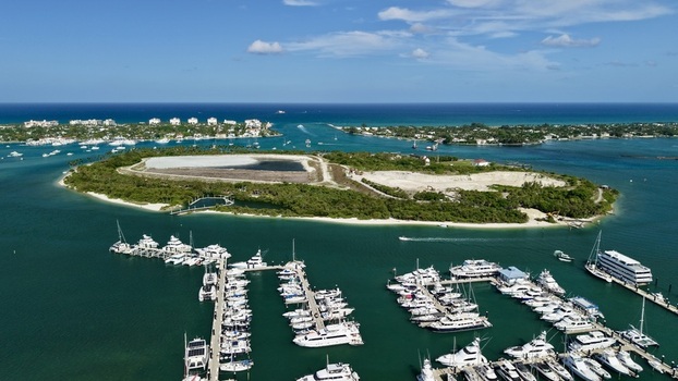 Aerial view of Riviera Beach Marina Village with numerous yachts docked in turquoise water near Peanut Island under a clear blue sky Riviera Beach Florida United States. Aerial view of Riviera Beach Marina Village with numerous yachts docked in turquoise water near Peanut Island under a clear blue sky Riviera Beach Florida United States.