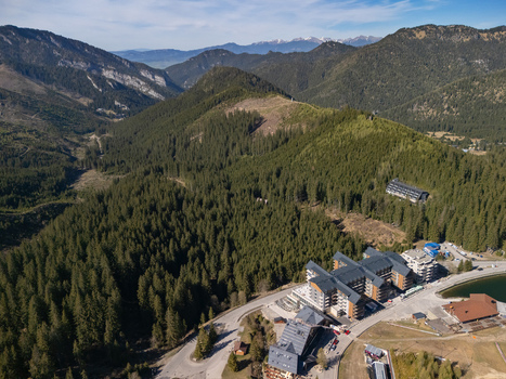 Aerial view of the Demanovska Dolina resort with modern hotels and dense evergreen forests under a clear blue sky in the Low Tatras mountains Demanovska Dolina Zilina Region Slovakia.