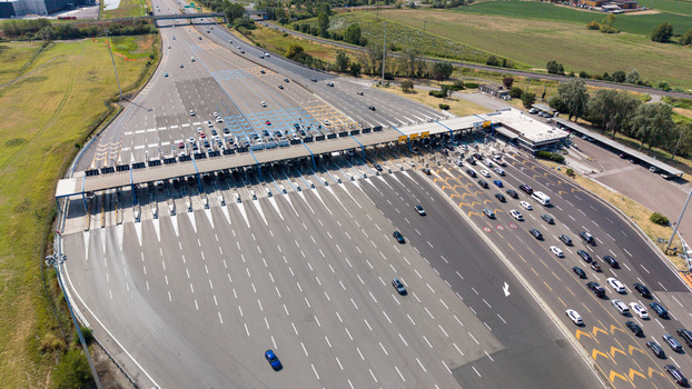 Aerial view of the Milano Sud toll plaza on the A1 motorway featuring vehicle traffic highway infrastructure and transportation systems in Melegnano Lombardy Italy.