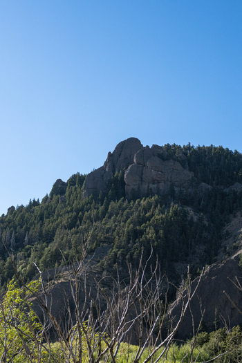 View of the rocky peaks and forested slopes along Ruta Provincial 63 under a clear blue sky Neuquen Argentina. View of the rocky peaks and forested slopes along Ruta Provincial 63 under a clear blue sky Neuquen Argentina.