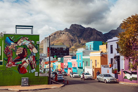 View of colorful houses in the Bo Kaap neighborhood with a large mural and Table Mountain in the background Cape Town Western Cape South Africa. View of colorful houses in the Bo Kaap neighborhood with a large mural and Table Mountain in the background Cape Town Western Cape South Africa.