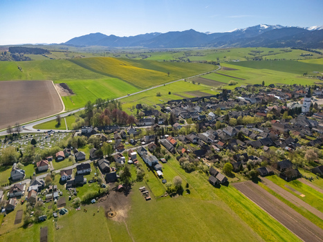 Aerial view of the village with its traditional houses and church tower surrounded by green fields and mountains in Partizanska Lupca Zilina Region Slovakia.