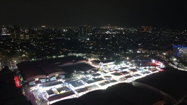 Aerial view of the illuminated JIEXPO Convention Centre and Theatre at night with surrounding urban lights and city skyline in Kecamatan Kemayoran Daerah Khusus Ibukota Indonesia. Aerial view of the illuminated JIEXPO Convention Centre and Theatre at night with surrounding urban lights and city skyline in Kecamatan Kemayoran Daerah Khusus Ibukota Indonesia.