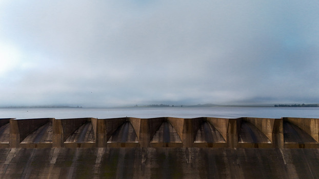 Aerial view of Spring Grove Dam wall and spillway overlooking the calm reservoir under a misty morning sky in Mooi River KwaZulu Natal South Africa. Aerial view of Spring Grove Dam wall and spillway overlooking the calm reservoir under a misty morning sky in Mooi River KwaZulu Natal South Africa.