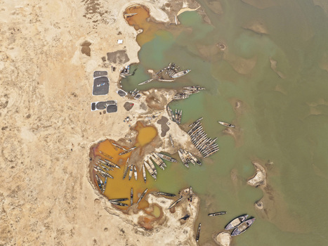 Aerial view of Jadukata River with numerous wooden boats moored along the sandy banks and shallow sediment rich water in Sunamganj Sylhet Division Bangladesh. Aerial view of Jadukata River with numerous wooden boats moored along the sandy banks and shallow sediment rich water in Sunamganj Sylhet Division Bangladesh.