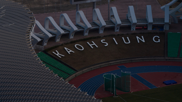 Aerial view of Kaohsiung National Stadium with its solar panel roof running track and large white lettering on the embankment in Juguang Village Kaohsiung City Taiwan.
