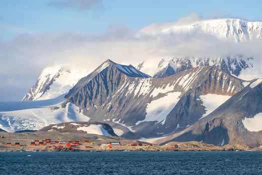 View of the red buildings of Esperanza Base set against snow covered mountains and glaciers in Esperanza Base Antarctica. View of the red buildings of Esperanza Base set against snow covered mountains and glaciers in Esperanza Base Antarctica.