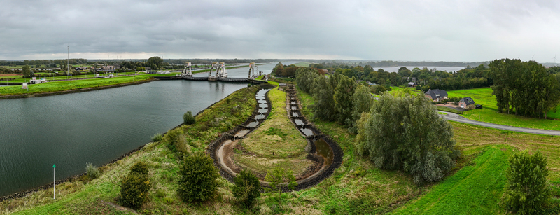 Aerial view of Sluis en stuwcomplex Hagestein on the Lek river featuring the weir and lock complex green fields trees anda fish ladder Hagestein Utrecht Netherlands.