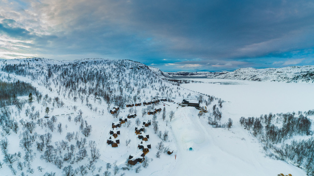 Aerial view of the Snowhotel complex surrounded by snow covered trees and a frozen lake in Kirkenes Finnmark Norway. Aerial view of the Snowhotel complex surrounded by snow covered trees and a frozen lake in Kirkenes Finnmark Norway.