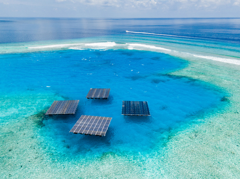 Aerial view of SolarSea floating solar power plant by Swimsol with four platforms in a turquoise lagoon surrounded by coral reefs in Dharavandhoo Baa Atoll Maldives. Aerial view of SolarSea floating solar power plant by Swimsol with four platforms in a turquoise lagoon surrounded by coral reefs in Dharavandhoo Baa Atoll Maldives.