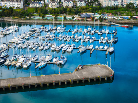 Aerial view of Bangor Harbour and Town with numerous sailboats moored at the docks calm blue water and coastal buildings in Bangor Northern Ireland United Kingdom.