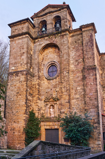 Pasai Donibane Spain 09 March 2026 View of the historic stone facade of the Church of San Juan Bautista with its bell tower and rose window.