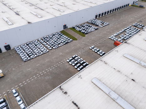 Aerial view of a large logistics warehouse facility with rows of new cars parked in the lot in Gdansk Poland. Aerial view of a large logistics warehouse facility with rows of new cars parked in the lot in Gdansk Poland.
