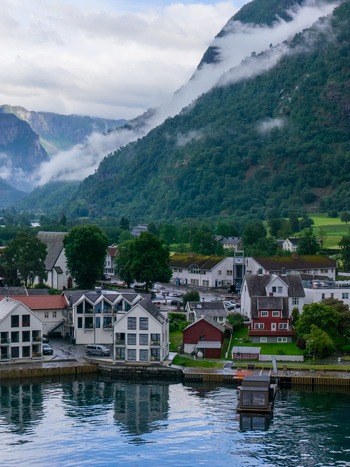 Flam Norway 19 June 2026 Aerial view of the village of Flam in the Aurlandsfjord valley featuring wooden houses a church and lush green mountains under low hanging clouds. Flam Norway 19 June 2026 Aerial view of the village of Flam in the Aurlandsfjord valley featuring wooden houses a church and lush green mountains under low hanging clouds.