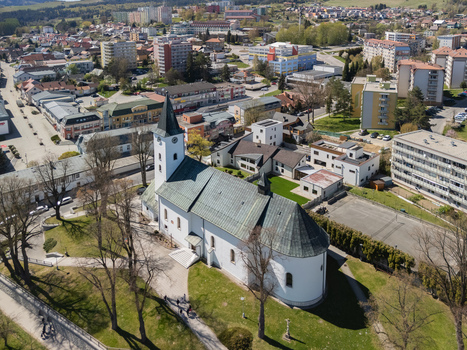 Aerial view of the Roman Catholic Church of Saints Simon and Jude with its white walls and green roof surrounded by trees and urban buildings in Namestovo Zilina Region Slovakia. Aerial view of the Roman Catholic Church of Saints Simon and Jude with its white walls and green roof surrounded by trees and urban buildings in Namestovo Zilina Region Slovakia.