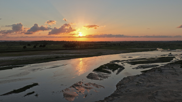 Aerial view of River Sabaki at sunset with winding river channels and sandbanks under a golden sky in Malindi Kilifi County Kenya.