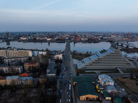 Aerial view of the National Library of Latvia and the Akmens tilts bridge spanning the Daugava River towards the historic Old Riga skyline at sunset Riga Latvia. Aerial view of the National Library of Latvia and the Akmens tilts bridge spanning the Daugava River towards the historic Old Riga skyline at sunset Riga Latvia.