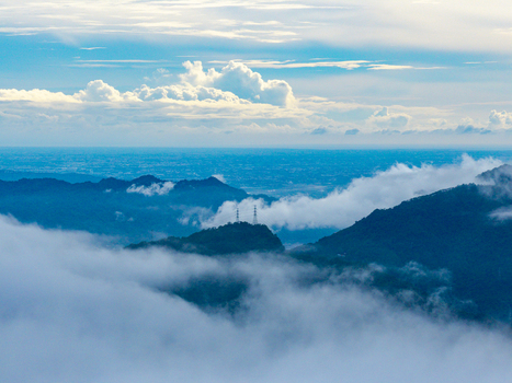 Aerial view of mountain peaks rising above a sea of clouds with transmission towers visible on a ridge in Yuchi Township Nantou County Taiwan. Aerial view of mountain peaks rising above a sea of clouds with transmission towers visible on a ridge in Yuchi Township Nantou County Taiwan.