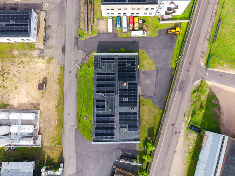 Olaine parish Latvia 04 July 2026 Aerial view of a commercial building roof covered with solar panels surrounded by asphalt roads parking areas and green spaces in an industrial zone. Olaine parish Latvia 04 July 2026 Aerial view of a commercial building roof covered with solar panels surrounded by asphalt roads parking areas and green spaces in an industrial zone.