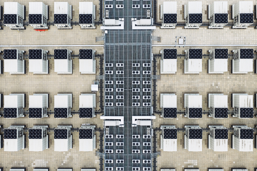 Aerial view of a data center roof with rows of industrial HVAC cooling units and ventilation systems in the United Kingdom.