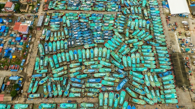 Aerial view of Malpe Fishing Harbour with numerous turquoise fishing boats docked in rows in Udupi Karnataka India. Aerial view of Malpe Fishing Harbour with numerous turquoise fishing boats docked in rows in Udupi Karnataka India.