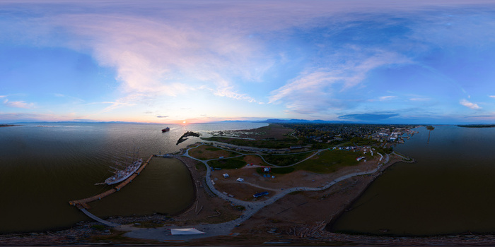 Aerial view of a coastal park at sunset with a docked ship winding pathways and calm waters in Metro Vancouver A British Columbia Canada.