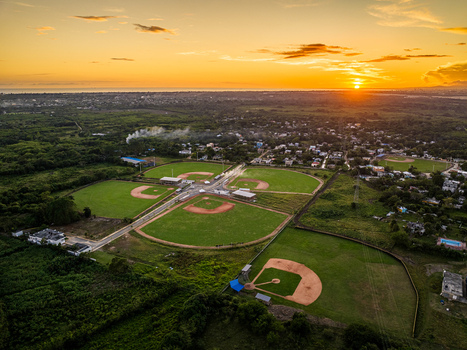 Aerial view of Quality Baseball Academy with multiple baseball fields surrounded by lush greenery at sunset in San Antonio de Guerra Santo Domingo Provinc Dominican Republic. Aerial view of Quality Baseball Academy with multiple baseball fields surrounded by lush greenery at sunset in San Antonio de Guerra Santo Domingo Provinc Dominican Republic.