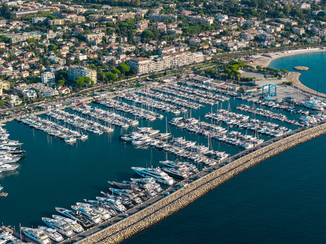 Aerial view of Port Vauban in Antibes featuring luxury yachts and sailboats docked in the marina protected by a long stone breakwater Antibes Provence Alpes Cote d Azur France. Aerial view of Port Vauban in Antibes featuring luxury yachts and sailboats docked in the marina protected by a long stone breakwater Antibes Provence Alpes Cote d Azur France.